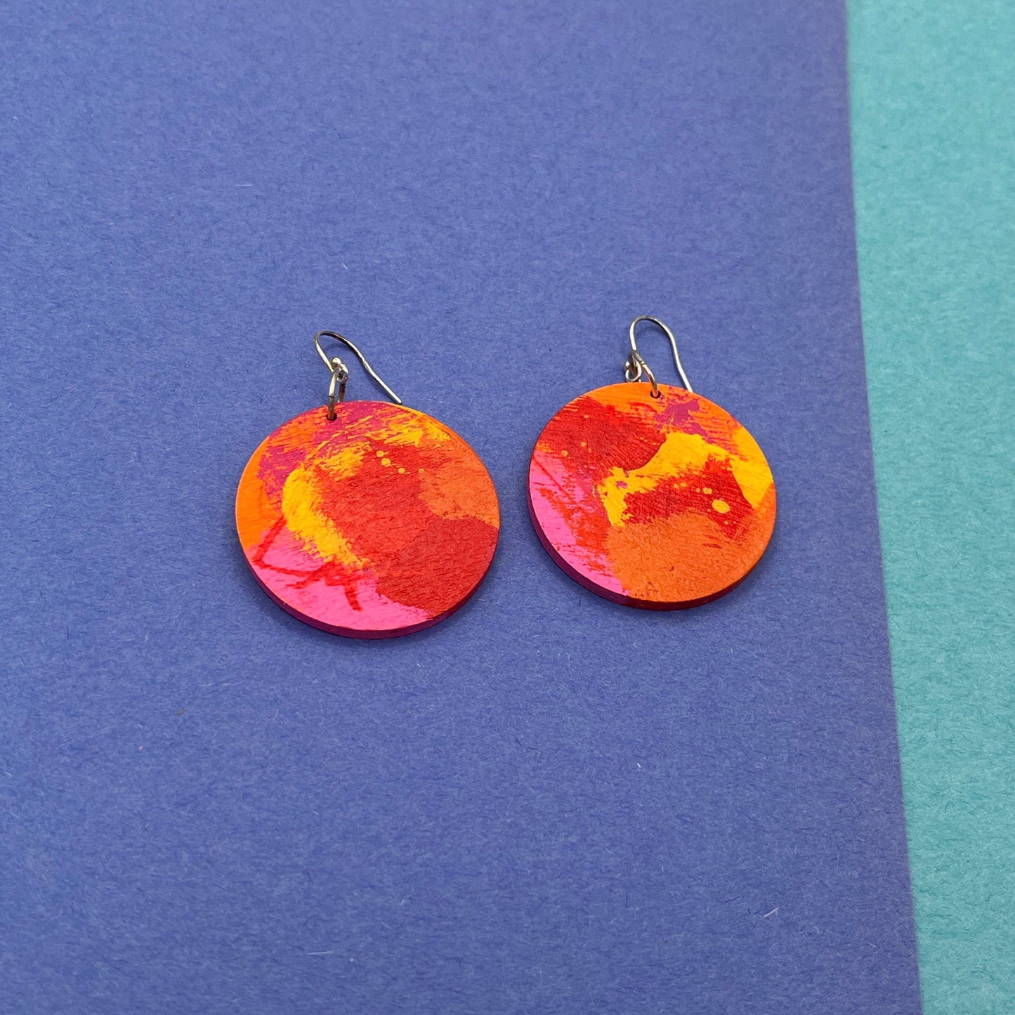 Colorful round earrings on a blue background