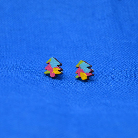 A pair of small multicolor tree-shaped stud earrings on a textured blue background.