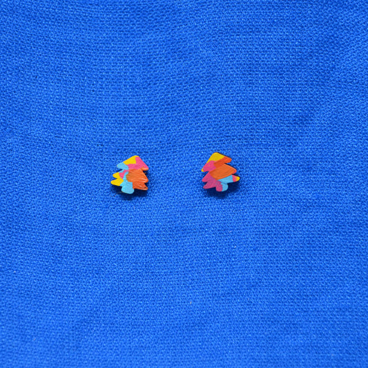 A pair of small multicolor tree-shaped stud earrings on a textured blue fabric background.