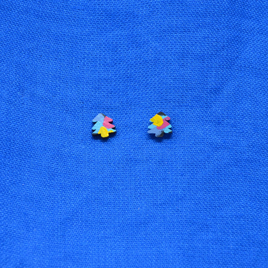 A pair of small multicolor tree stud earrings on a textured bright blue fabric background.