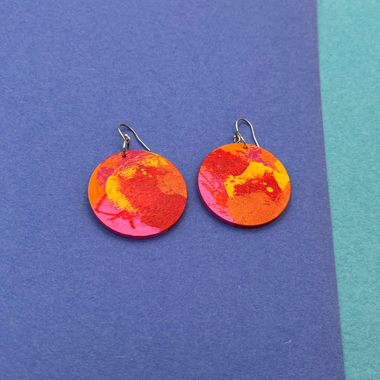 Colorful round earrings on a blue background