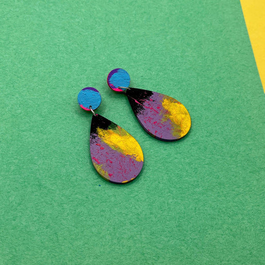 Colorful teardrop-shaped earrings on a green background