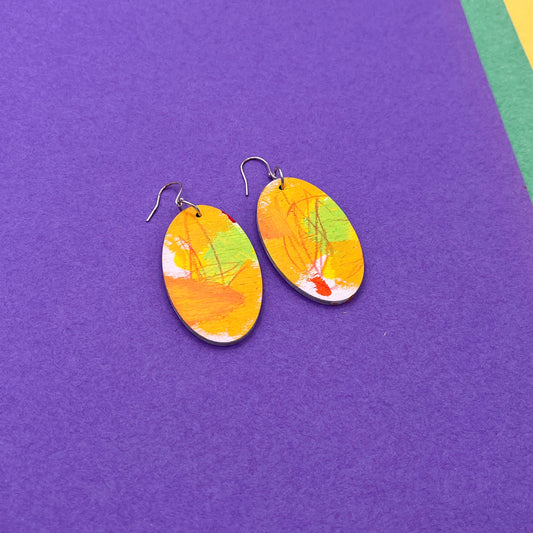 Colorful oval earrings on a purple background